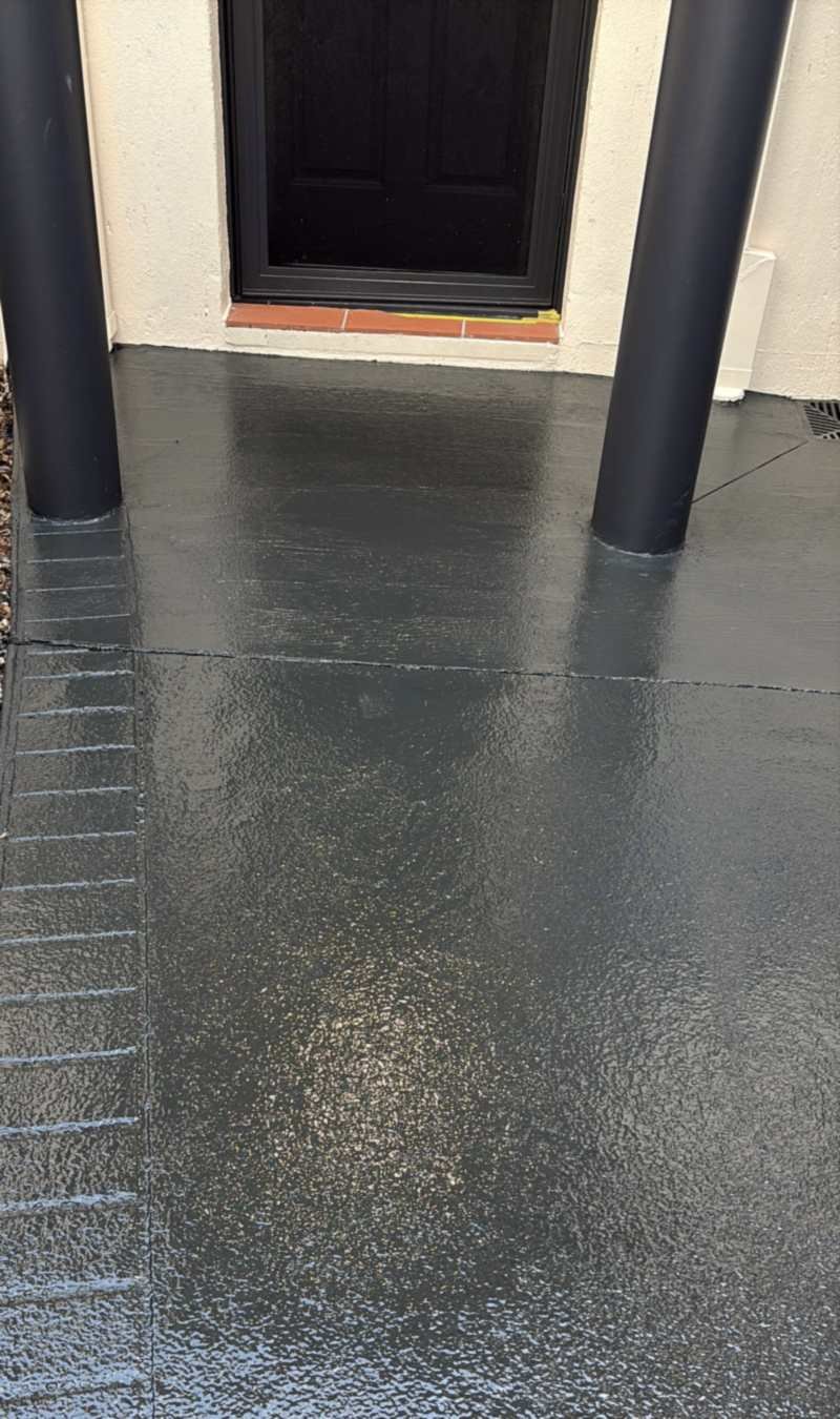 Front porch between two black posts, coated in a glossy charcoal finish