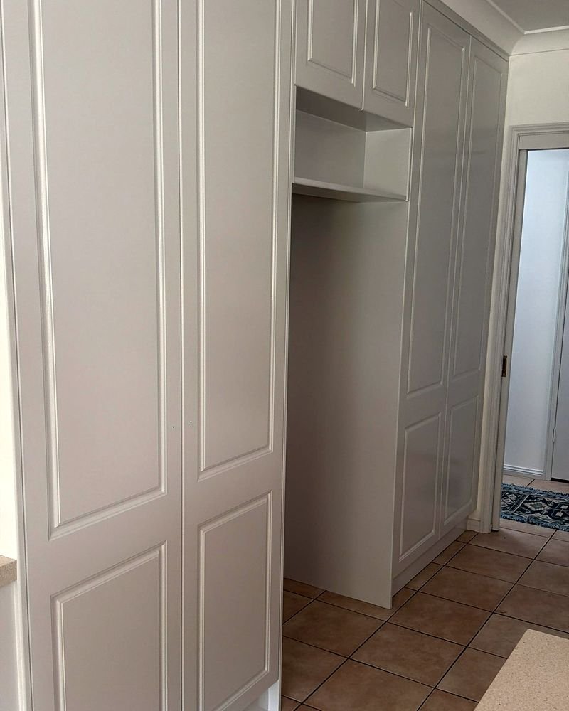 Tall run of white-painted cabinetry with crisp, even edges